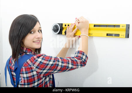 Brünette Frau mit Wasserwaage Stockfoto