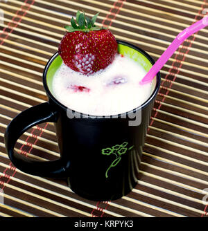 Milch cocktail in einem schwarzen Becher auf einem Teppich Stockfoto