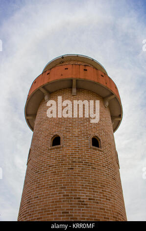 Der alte Leuchtturm mit blauem Himmel und weißen Wolken. Leuchtturm aus roten Ziegeln. Stockfoto