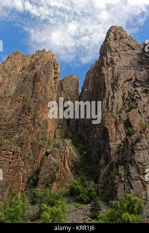 Felswände ragen hohe Gemeinkosten, gesehen vom Fußboden des Black Canyon des Gunnison in Colorado. Stockfoto