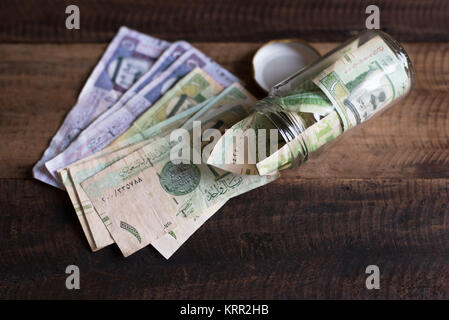 Saudi Riyal Banknoten Geld in Glas und Holz Tisch. Einsparungen Konzept Stockfoto