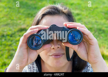 Close up junge Frau durch ein Fernglas in der Natur suchen Stockfoto