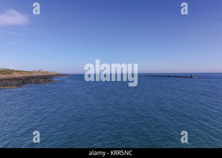 Suchen von craster Hafen Dunstanburgh Castle in der Ferne, an der nordöstlichen Küste von Northumberland. Stockfoto