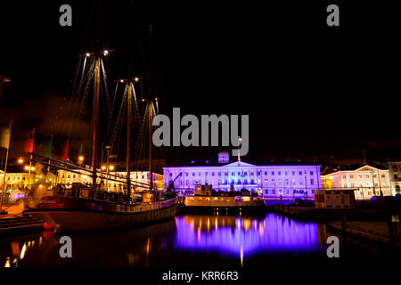 Beleuchtete Rathaus und Alte hölzerne Segelschiff mit hohen Masten in der Nacht in Helsinki, Finnland Stockfoto