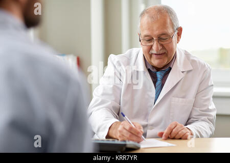 Arzt schreiben Rezept für Patienten an der Klinik Stockfoto