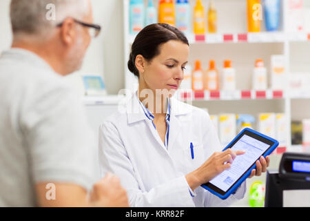Apotheke und Kunden mit Tablet-PC in der Apotheke Stockfoto