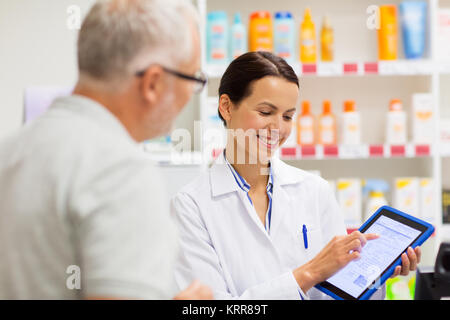 Apotheke und Kunden mit Tablet-PC in der Apotheke Stockfoto