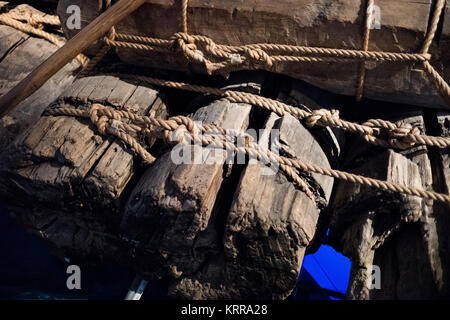 Kon-Tiki Raft Construction Details Oslo Norwegen // OSLO, Norwegen — das Kon-Tiki Raft, das im Kon-Tiki Museum ausgestellt wird, zeigt die traditionellen südamerikanischen Bautechniken, die Thor Heyerdahl bei seiner berühmten Pazifik-Überquerung von 1947 einsetzte. Die Balsaholzstämme des ursprünglichen Floßes werden mit natürlichen Hanfseilen in einem komplizierten Kreuzverschlussmuster zusammengebunden, was die alte peruanische Schiffbautechnik demonstriert, die Heyerdahl zu validieren suchte. Im Primärbau wurden keine Metallbauteile verwendet, was den präkolumbianischen Baumethoden treu blieb. Die Bindungstechnik erlaubte das Floß Stockfoto