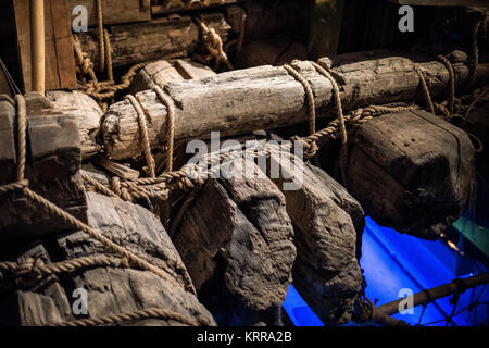Kon-Tiki-Floß Balsa Holzbau Kon-Tiki Museum Oslo Norwegen // OSLO, Norwegen — das Kon-Tiki-Floß, ausgestellt im Kon-Tiki Museum, zeigt die traditionellen südamerikanischen Bautechniken, die Thor Heyerdahl bei seiner berühmten Pazifik-Überquerung von 1947 einsetzte. Die Balsaholzstämme des ursprünglichen Floßes werden mit natürlichen Hanfseilen in einem komplizierten Kreuzverschlussmuster zusammengebunden, was die alte peruanische Schiffbautechnik demonstriert, die Heyerdahl zu validieren suchte. Im Primärbau wurden keine Metallbauteile verwendet, was den präkolumbianischen Baumethoden treu blieb. Die Bindungsmethode Stockfoto