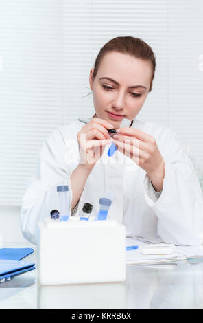 Porträt eines jungen Wissenschaftlers, Tech oder Diplomand Kennzeichnung Rohr für das Experiment. Flache DOF, auf dem Gesicht konzentrieren Stockfoto