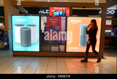 Käufer weitergeben einer Amazon Kiosk im Queens Center Mall im Stadtteil Queens in New York am Sonntag, 17. Dezember 2017, eine Woche vor Weihnachten. Die Einzelhändler berichten von einer Beule im Vertrieb für Weihnachten Ansätze wie locken Sie potenzielle Kunden und Fuß Verkehr zu erhöhen. (© Richard B. Levine) Stockfoto