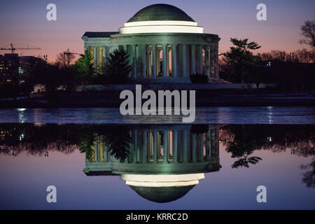 Jefferson Memorial Reflection Tidal Basin Washington DC // WASHINGTON DC – das Jefferson Memorial spiegelt sich am frühen Morgen vor Sonnenaufgang auf den stillen Gewässern des Tidal Basin wider. Das neoklassizistische Denkmal, das Thomas Jefferson, dem dritten Präsidenten der Vereinigten Staaten und Hauptautor der Unabhängigkeitserklärung, gewidmet ist, erzeugt ein symmetrisches Spiegelbild auf der ruhigen Oberfläche des Wassers. Das Denkmal wurde zwischen 1939 und 1943 erbaut und befindet sich am Ufer des Tidal Basin, einem Teil des West Potomac Park. Besonders beliebt ist die Gegend im Frühling, wenn Kirschbäume umgeben sind Stockfoto
