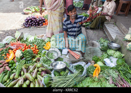 Pflanzliche Verkäufer mit einer Waage Möhren in die garia Bezirk von Kolkata, Indien zu wiegen Stockfoto