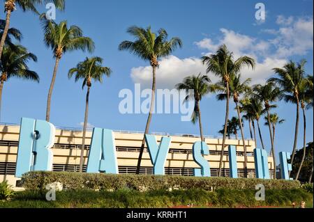 Bayside Zeichen mit tropischen Palmen, blauer Himmel und städtischen Gebäuden, außerhalb der Bayside Marketplace in Miami, Florida, USA. Stockfoto