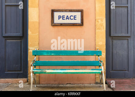 Wort Frieden über eine alte Holzbank auf eine Spalte zwischen zwei Türen eingerahmt. Nähe zu sehen. Stockfoto