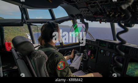 Ein US Air Force Soldat fliegt eine C-130J Super Herkules Flugzeug über dem Pazifischen Ozean während des Betriebs Weihnachten Drop Dezember 8, 2017 in der Nähe von Rota. Stockfoto