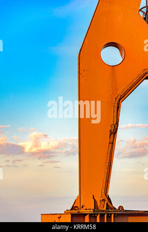 Detail der Große der alte Kran von unten mit blauem Himmel gesehen und einige Wolken im Hintergrund bei Sonnenuntergang Stockfoto