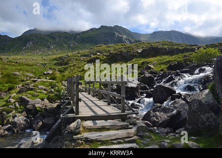 Brücke über Stream am Llyn Ogwen Richtung Mount Tryfan, Snowdonia, Wales, Großbritannien Stockfoto