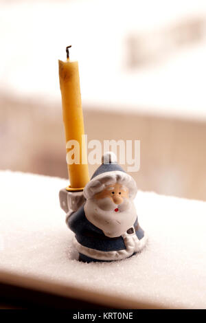 Unter einer Kerze in Form von Väterchen Frost zu unterstützen Stockfoto