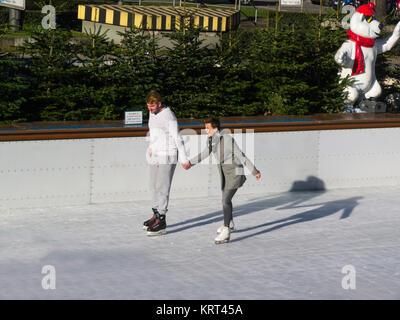 Junge Menschen und Frauen halten sich an den Händen skating Münchener EisZauber München Ice Magic Eisbahn Stachus Karlsplatz München Bayern Deutschland EU Stockfoto