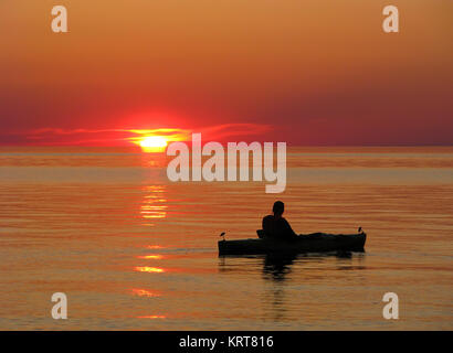 Kayaker geniesst den Sonnenuntergang auf die stillen Wasser des Lake Superior Stockfoto