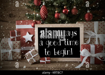 Nostalgische Karte für Seasons Greetings. Weihnachtsbaum mit Kugeln und Schneeflocken. Geschenke oder stellt Vor Holz- Hintergrund. Schiefertafel mit englischen Text Zitat Es ist immer ein guter Zeitpunkt, um zu beginnen Stockfoto
