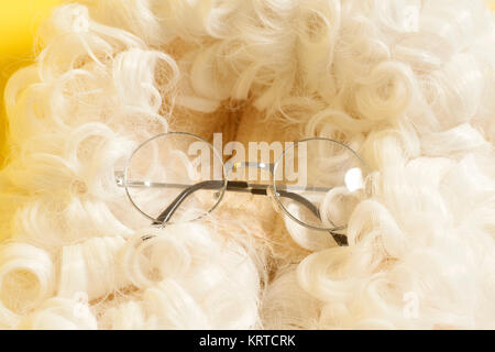 Brillen auf Richter Perücke auf gelben Hintergrund. Stockfoto