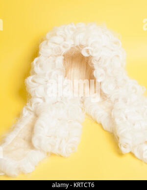 Perücke auf gelbem Hintergrund beurteilen. Stockfoto