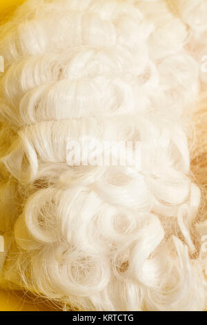 Perücke auf gelbem Hintergrund beurteilen. Stockfoto