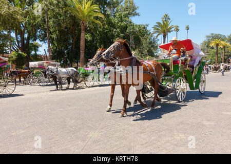 Marrakesch, Marokko - Mai 12, 2017: Kutsche Touristen, die für eine Fahrt auf der Straße nach Jemaa el-Fnaa Platz in Marrakesch, Marokko Stockfoto