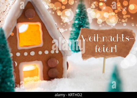 Deutsche Text bedeutet Weihnachtsfeier Weihnachtsfeier. Lebkuchenhaus in der verschneiten Landschaft als Weihnachtsdekoration. Weihnachtsbäume und Kerzenschein. Bronze- und orangefarbenen Hintergrund mit Bokeh Wirkung. Stockfoto