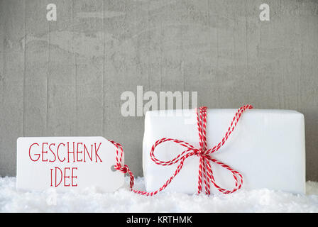 Etikett mit deutschem Text Geschenk Idee bedeutet Geschenk Idee. Ein Weihnachtsgeschenk oder auf Schnee. Zement oder Beton Wand als Hintergrund. Moderne und den urbanen Stil. Stockfoto