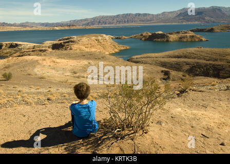 Frau sitzt am Strand am Lake Mead National Recreation Area Nevada, USA. Stockfoto