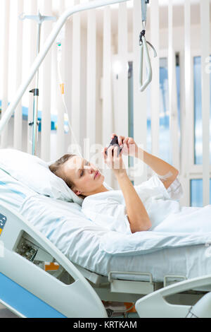 Hübsche, junge, weibliche Patienten in ein modernes Krankenhaus. Besser schnell nach einer Chirurgie - nachdenklich, aber positiv, weiter zu denken, machen Pläne (flacher DOF Farbe getonte Bild) Stockfoto