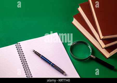 Notebook mit Lupe Glas und Bücher. Stockfoto