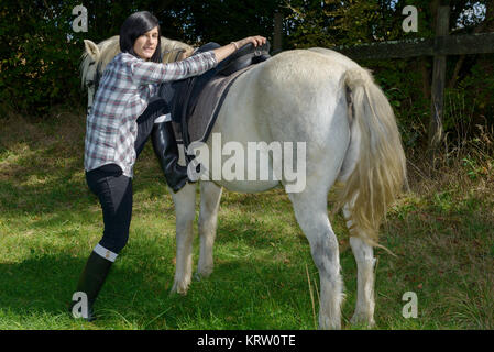 Junge schöne Brünette Frau Reiten Stockfoto