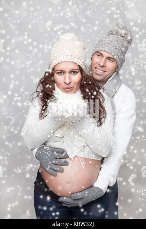 Glückliche Paare, die ein Baby erwarten im Winter Stockfoto