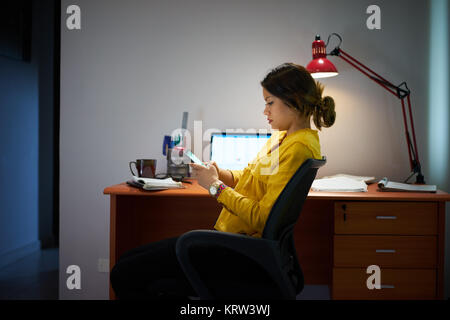 Mädchen Schüler studieren in der Nacht Arten Nachricht auf dem Telefon Stockfoto