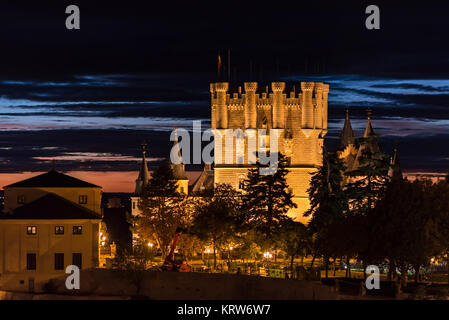 Die alcazar von Segovia, Spanien leuchtet in der Dämmerung mit einer verblassenden Sonnenuntergang im Hintergrund Stockfoto