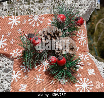Nahaufnahme von hausgemachten Weihnachten pin aus Tannenzapfen, kiefer Blätter und Beeren auf Schal von Weihnachten rasen Dekoration Stockfoto