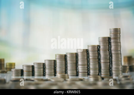 Stzck von Münzen mit Holz- Scrabble Buchstaben Stockfoto