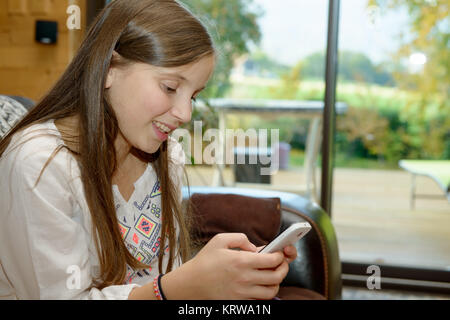 Junger Teenager auf dem Sofa sendet eine Sms. Stockfoto