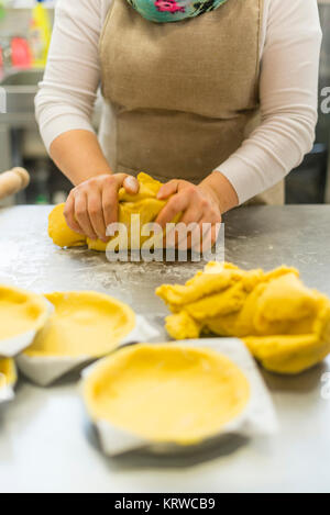 Chef Gebäck Bäcker Frau Vorbereitung und Ausarbeitung der dought mit Eiern Olivenöl Mehl Salz und Wasser für die Schaffung von Kuchen Cookies und Süßigkeiten gemacht. Stockfoto