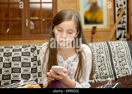 Junger Teenager auf dem Sofa sendet eine Sms. Stockfoto