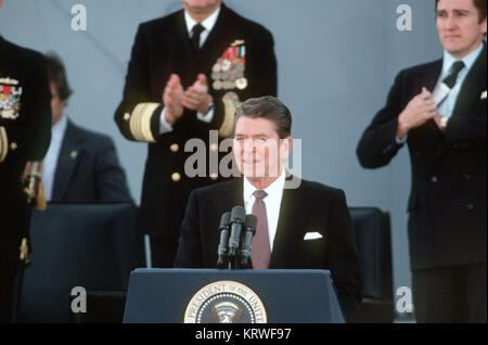 Präsident Ronald Reagan, Hauptredner, Adressen der Gäste zur wiederinbetriebnahme Zeremonie für das Schlachtschiff USS NEW JERSEY (BB-62). Hinter ihm auf der rechten Seite ist Sekretär der Marine John F. Lehman jr. Stockfoto