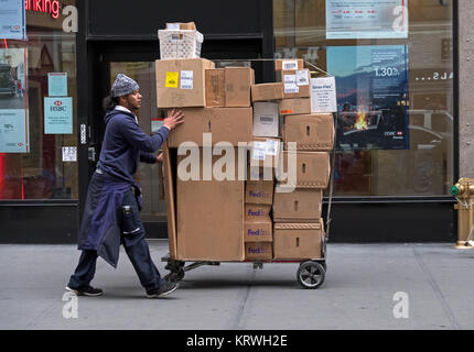 Ein Fedex Delivery Man bietet Dutzende von Schachteln zu einem Bürogebäude am Broadway in der Nähe von Herald Square in Manhattan. Stockfoto