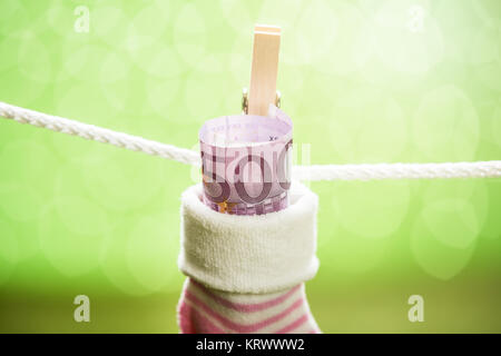 Baby Socken mit Dollar hängen am Seil Stockfoto