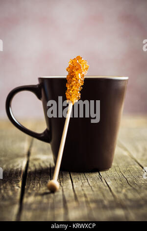 Braun gelb Zucker Kristall auf Holzstab und Kaffee Tasse. Stockfoto