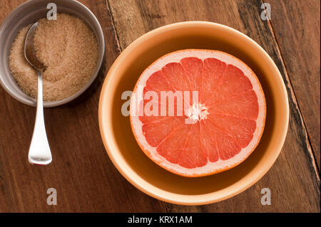 Frische halbiert rosa Grapefruit, serviert mit Zucker Stockfoto