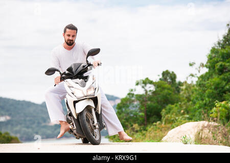 Brutale Biker mit Bart tragen weiße sitzen auf dem Motorrad in den Bergen. Stockfoto